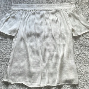 Vit off shoulder topp - Säljer denna jättefina vita off shoulder toppen från second female🌸💗💗Oanvänd, den är som ny!💗Pris kan diskuteras!