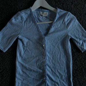 Jätte fin tröja/kofta med knappar - Säljer denna super söta tröjan/koftan med små knappar på som man kan öppna och stänga om man vill. Fin v-ringning och så fin blå färg. Lite för liten på mig tyvärr. Köpt på Lindex storlek xs