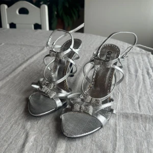Silvriga klackar - Silvriga klackar med rosetter i storlek 39💓 9 cm klack och i mycket gott skick💓Tryck gärna på köp nu