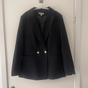 Kavaj med guldknappar - Fin kavaj köpt från H&M i storelk 38. Jätte fin passform och har guldknappar på, använd vid få tillfällen. 