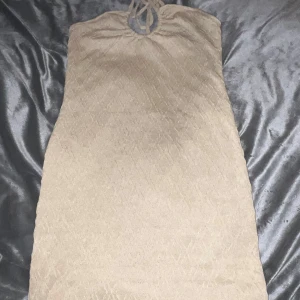 Tube klänning - Beige tube-klänning från H&M. Endast testad. Det är Snörning runt nacken och den slutar ovanför knäna.