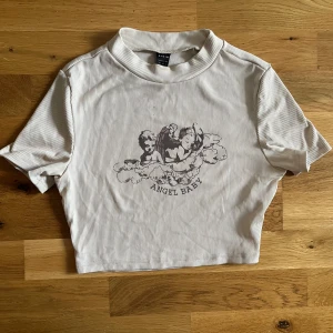 Crop top ”Angel Baby” - Jättefin crop top som säljes pga att den inte används längre. Fint skick. Stretchig och väldigt bekväm.