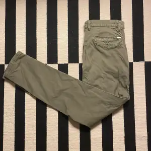 Säljer ett par olivgröna chinos från Jack & Jones i storlek 33/34. Byxorna har en slim passform och är perfekta för både vardag och fest. Nypris: 600kr