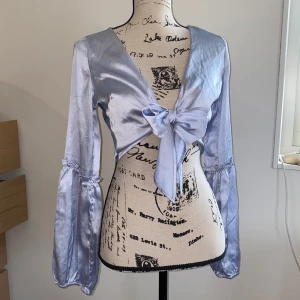 Knyttopp Omlottopp Blå Satin - • Nyskick, aldrig använd • Upplevs som 36 (står 36) • Passform smal-normal • Alla bilder visar färg och material bra • Tunnt och lent Samet/Satin-tyg • Går att knytas på olika sätt • Fråga gärna! Fler bilder kan fixas