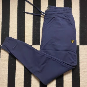 Blå mjukisbyxor från Lyle & Scott - Säljer ett par snygga blå mjukisbyxor från Lyle & Scott. De är superbekväma och perfekta för en chill dag hemma. Byxorna är i nyskick! Nypris: 800kr