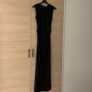 Svart klänning  - Svart klänning,  Aldrig använd med slits i bak Köpt för 700 kr