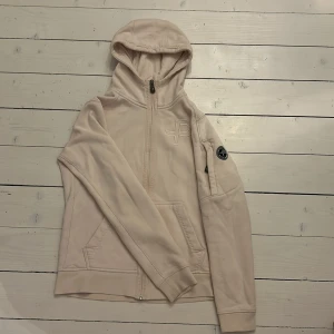 Ljusrosa Pelle Pettersson hoodie - En ljusrosa Pelle Petterssontröja med dragkedja och luva. Hoodien har även fickor och är i fint skick. Normal passform. 