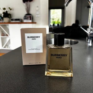 Burberry Hero Eau de Toilette 100 ml - Säljer en elegant och stilren Burberry Hero Eau de Toilette. Flaskan rymmer 100 ml. Doften är fräsch och maskulin, perfekt för dagligt bruk eller speciella tillfällen. Kommer i en snygg beige kartong. Oanvänd, endast tagit ett sprut. Nypris: 1465 kr.
