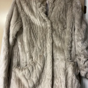 Beige pälsjacka från ONLY - Säljer en supermjuk och fluffig beige pälsjacka från ONLY i storlek L. Perfekt för att hålla sig varm och stilren under kalla dagar. Jackan har långa ärmar och en elegant design som passar både till vardags och fest. Ett måste för vintern! ❄️