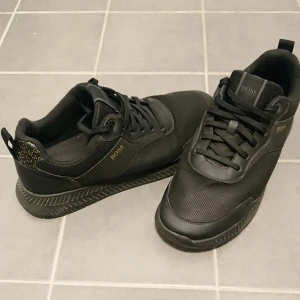 Äkta Hugo Boss skor storlek 45!!! - Säljer ett par snygga & fräscha Hugo Boss skor bra skick. Skorna har en snygg design med snörning och en diskret logga på sidan. Perfekta för både vardag och fest! 🖤