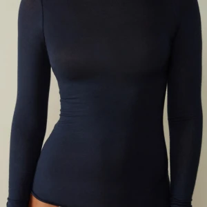 Mörkblå långärmad topp från Missimi - Säljer en mörkblå långärmad topp från Missimi i storlek M. Toppen är tight och har en elegant, enkel design som passar perfekt till både vardag och fest. Materialet är mjukt och stretchigt för en bekväm passform.