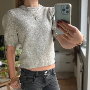 Grå stickad tröja från NA-KD - Priset kan diskuteras!❣️                                        Säljer en superfin grå stickad, kortärmad tröja från NA-KD i storlek XS. Den har puffiga kortärmar och är mjuk och bekväm!❤️ Säljer på grund av för lite användning, då jag bara använt den en gång! Den är i fint skick och säljer den lite billigare än vad jag köpte den för att den är lite nopprig vi högra ärmen❤️