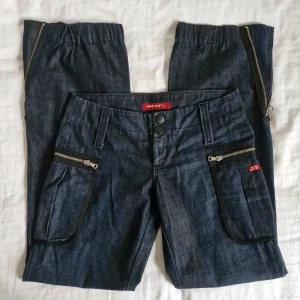 Baggy vintagejeans Miss Sixty - Fantastiska vintagejeans från Miss Sixty 🎀 I mycket fint skick! Unik modell med låg midja, baggy passform, cargofickor och dragkedjor i bensluten. Perfekt 90-tals statement piece! Midjemått: 39 cm. Totallängd: 100 cm. Innerbenslängd: 79 cm.