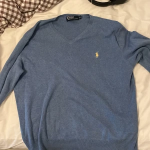 Ralph lauren v neck tröja - En polo by ralph lauren tröja i blå som passar killar runt 175. Väldigt bra skick utan några särskilda fel över huvud taget!