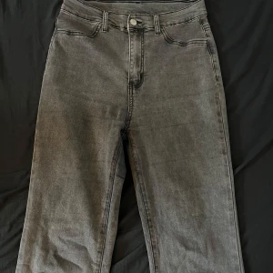 Grå jeansbyxor - Säljer ett par snygga grå jeansbyxor i mycket bra skick. De har en klassisk femficksdesign och är högmidjade för en bekväm passform. Perfekta för både vardag och fest! 🖤