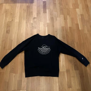 Svart sweatshirt från New Balance - Säljer en svart sweatshirt från New Balance i storlek M. Tröjan har en klassisk design med New Balance-loggan tryckt på framsidan. Perfekt för en avslappnad stil eller träning. Den är i mycket bra skick och redo för nya äventyr! Skriv för fler bilder och frågor.