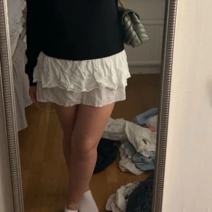 Vit volangkjol - Säljer en superfin vit volangkjol som är perfekt för sommaren! Kjolen har flera lager med volanger som ger en söt och lekfull look. Den är kort och passar perfekt till både vardag och fest. Materialet är lätt och luftigt, vilket gör den bekväm att bära hela dagen.