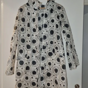 Prickig regnjacka från Marimekko - Säljer en superfin prickig regnjacka från Marimekko i storlek S. Den är vit med svarta prickar och har långa ärmar. Perfekt för regniga dagar och har en stilren design. Jackan är i oanvänt skick och redo för nya äventyr! 🌧️