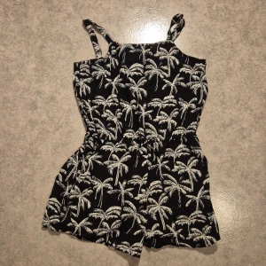 Kort byxdress - Byxdress med korta ben, palm-tryck, axelbanden går att justera, använd men i bra skick