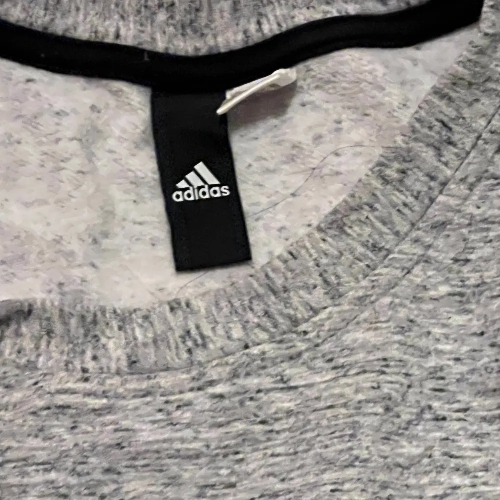 Säljer en snygg och bekväm grå tröja från Adidas. Perfekt för både träning och vardag. Tröjan har en normal passform och är tillverkad i mjukt material som känns skönt mot huden. Den är långärmad och har en enkel design som passar till det mesta. Perfekt för höst och vår!säljs för 60. Tröjor & Koftor.