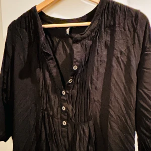 Svart blus  - Svart blus från Miss Baron i storlek 42.