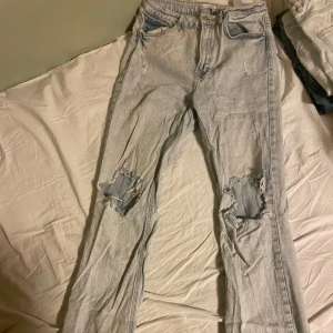 Zara Jeans  - Storlek 38 i ljusblå med slitna detaljer, utsvängda nedtill med slits.  Fåtal defekter så som en mindre fläck över knät och missfärgat längst ned då dem blivit trampade på (går eventuellt bort eller så kan man klippa ner dem) annars fint skick! 