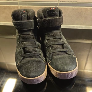 Svarta sneakers från Viking - Säljer ett par svarta Viking sneakers i storlek 39. De är gjorda i slitstarkt material med Gore-Tex för extra skydd mot väta. Skorna har snörning och en praktisk rem upptill för bättre passform. Perfekta för höst och vår! Sätter färg svart men lite osäker.