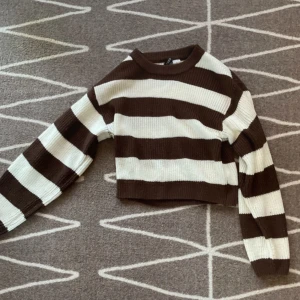 Brun och vit randig tröja från H&M - Säljer en superfin brun och vit randig tröja från H&M. 100% akryl
