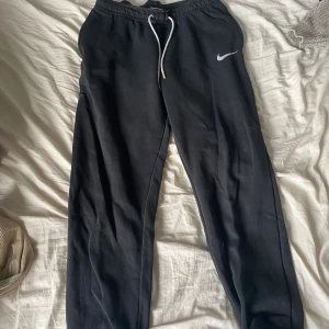 Nike mjukis - Ett par nike mjukis. Sköna och varma till vintern eller att använda hemma. Har två fickor med dragkedja på höfterna.