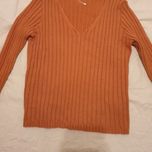 Tröja - Tröja med långa ärmar och V-ringning. Tröjan är randig och har en mörkbrun kant på ärmsluten.stretchig säljs för 50