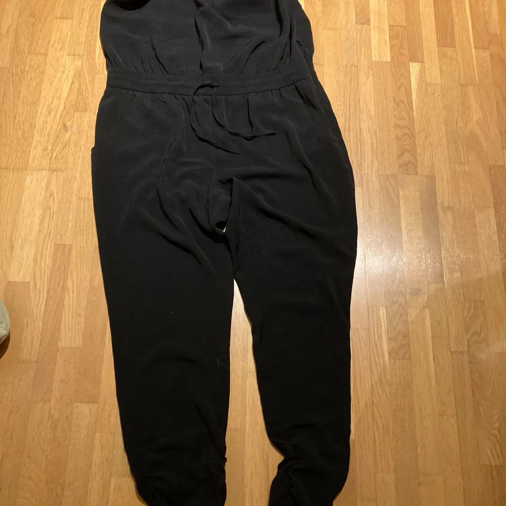 Svart jumpsuit från lindex  Knytband i midjan och axelbandet har två längder  Mycket fint skick . Jeans & Byxor.