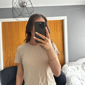 Beige t-shirt från Bik Bok - Säljer en beige t-shirt från Bik Bok i storlek M.
