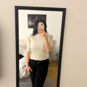 Beige ribbad topp - Säljer en stilren beige ribbad topp med puffiga axlar och trekvartsärm. Från Pernilla Wahlgren kollektion 