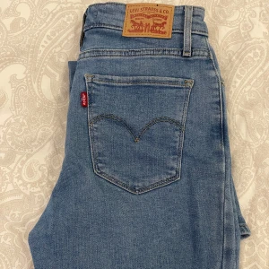 Levi's 725 High Rise Bootcut Jeans -  Levi's 725 high rise bootcut jeans i blå denim. Dessa jeans har en hög midja och bootcut. Mjuka jeans i ny skick. Använd väldigt få gånger då dem är för långa för mig