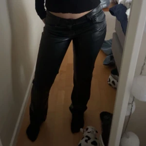 Svarta skinnbyxor - Snygga svarta skinnbyxor med låg midja och tight passform. Perfekta för en trendig look. Byxorna har en klassisk design med dragkedja och knappar framtill. Det är väldigt varma och är ganska töjbara!