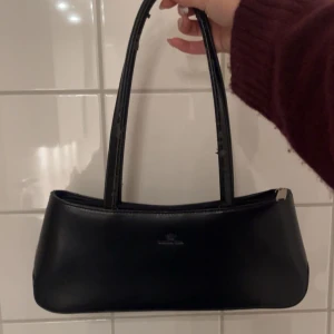 Svart axelväska - En svart väska från secondhand! Använd ett par gånger. Det har lossnat skinn från handtagen men annars är det inget annat som är fel!