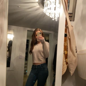 Beige croppad tröja - Säljer en stilren beige croppad tröja med långa ärmar. Perfekt för en avslappnad look. Passar bra till jeans eller kjol.