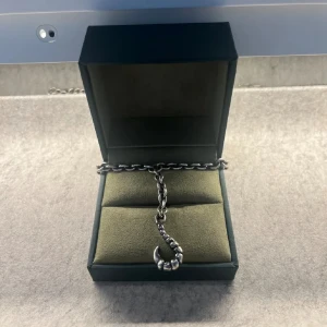 Maria Nilsdotter halsband - Stilrent silver halsband med en unik krokformad hängsmycke. Kedjan är robust och ger en cool look. Perfekt för att lägga till en edgy touch till din outfit. Från Maria Nilsdotter och knappt använd!