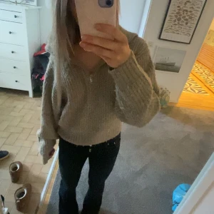 Beige stickad tröja med dragkedja - Mysig beige stickad tröja med dragkedja framtill. Perfekt för kyliga dagar med sin bekväma passform och långa ärmar. En stilren och enkel design som passar till det mesta. Köpt för 500