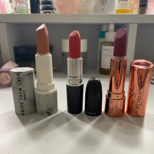 Tre läppstift från olika märken - Säljer tre snygga läppstift: ett nude från H&M i  Give Them Lala, ett rött från MAC i nyansen 'Lady Danger', och ett mörkrött från Revolution i nyansen 'Ruby'. Perfekta för att komplettera din sminksamling!