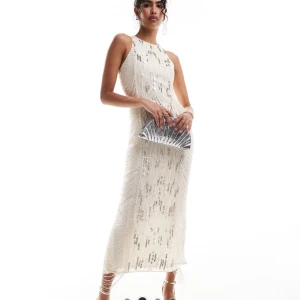 Vit glittrig långklänning - Elegant vit långklänning med glittriga detaljer. Klänningen är ärmlös och har en smickrande passform som framhäver figuren. Perfekt för festliga tillfällen.