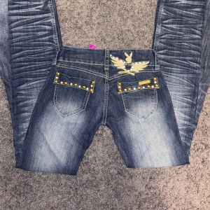 Playboy jeans med gulddetaljer - Snygga lågmidjade jeans från Playboy med unika gulddetaljer och broderad logga. Byxorna är utsydda till bootcut därmed en extra söm, innerbenslängd 84 cm, tvärs över midjan 36 cm ❤️ PRISET ÄR DISKUTERBART!!! ❤️