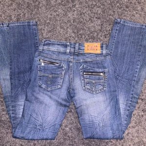 Blå jeans från BBJ Jeans - Snygga blå jeans från BBJ Jeans med coola detaljer som dragkedjor på bakfickorna. Byxorna är utsydda till bootcut, därmed en extra söm. Innerbenslängd 84 cm och tvärs över midjan 36 cm ❤️ PRISET ÄR DISKUTERBART!!! ❤️