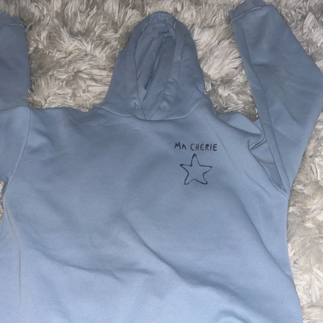 Ljusblå hoodie med texten 'Ma Chérie'