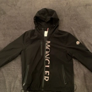 Svart Moncler Vindjacka - Moncler vindjacka helt ny, Storlek 1 Som är S för Moncler men kan även passa XS till M för man kan ändra passformen med spänn snören. Priset kan diskuteras:)