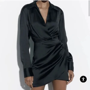 Svart omlottklänning - Elegant svart omlottklänning från Zara med långa ärmar och knappar vid ärmsluten. 