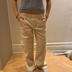 Beige cargopants - Snygga beige cargopants med flera fickor och en loose passform. Små defekter i form av fläckar på baksidan men knappt synliga 💕