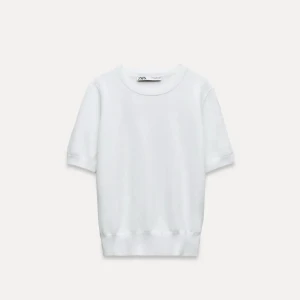 Vit kortärmad topp från Zara - Säljer en enkel och stilren vit kortärmad topp från Zara. Den är gjord av mjukt material och har en normal passform. Perfekt för både vardag och fest! 