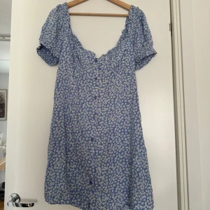 Blå blommig klänning - Aldrig använd då den var för stor är mer som en large. 