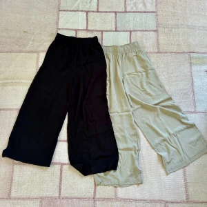 Cropped pull-on byxor - H&M  - Nya ankle-length byxor med hög midja och fickor från H&M i svart och beige, storlek 34/xs. Aldrig använda, säljs då de är för stora i midjan för mig. Köpte båda för 400kr.  Material: 100% viskos